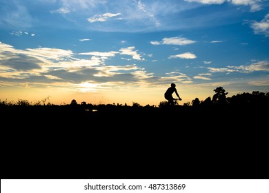 Silhouette of the cyclist riding a road bike at sunset - Shutterstock ID 487313869