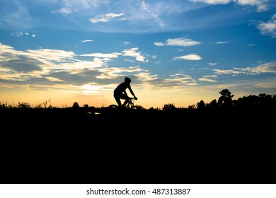 Silhouette of the cyclist riding a road bike at sunset - Shutterstock ID 487313887