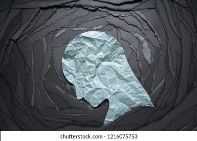 Silhouette depressiver und ängstlicher Person Kopf. Negatives Emotionsbild. Persönliches Kopfpapier auf schwarz zerrissenem Papierhintergrund.