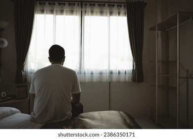 Silhouette depressed man sadly sitting on the bed in the bedroom. Sad asian men suffering depression insomnia awake and sit alone on the bed in bedroom. Depression health people concept. - Powered by Shutterstock