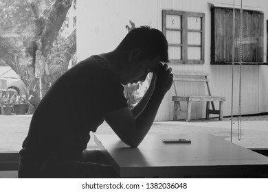 Silhouette of depressed man sitting. Black and white color.