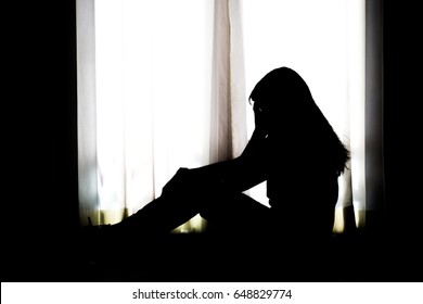 Silhouette Of Depressed And Sad Young Woman Sitting At The Window, Black And White Tone, Copy Space