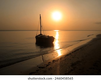 Silhouette of a Dhow at sunset, giving everything a golden color, in the quiet sheltered water of Maputo Bay at KaNyaka Island, Mozambique - Powered by Shutterstock