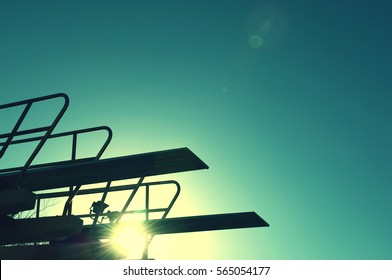 Silhouette of diving board at sunset