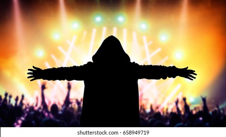 Silhouette of a dj on the party, people enjoying a good music on the concert, have fun on a dance floor, holidays and active nightlife concept