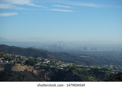 Silhouette Of Downtown Los Angeles Skyline In The Early Morning From High Atop The Hollywood Hills Behind West LA Buildings And Hollywood Hills Homes