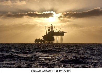 Silhouette Of A Drilling Rig In The North Sea At Sunset. Jack Up Drilling Rig.