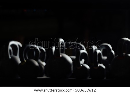 Silhouette Dumbbell for weight training in gym. Black kettlebells.  24kg. Weightlifting. Out of focus.