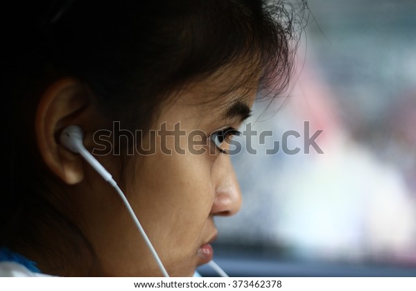\
Silhouette edge Asian girl\
sitting in the car listening to music from smartphone\
in-Thailand.