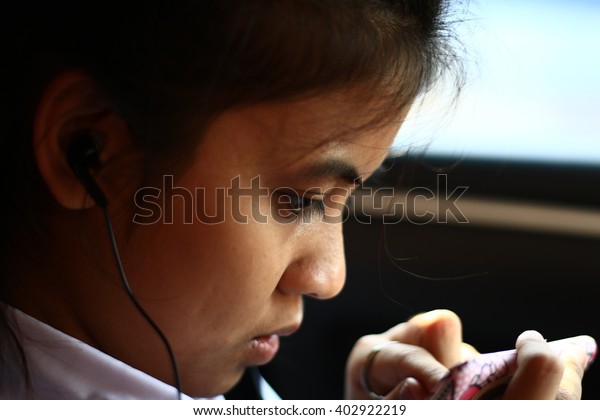 \
Silhouette edge Asian girl\
sitting in the  car listening to music from smartphone\
in-Thailand