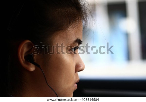 
Silhouette edge Asian girl
sitting in the car listening to music from smartphone
in-Thailand.