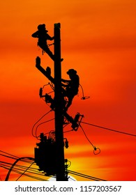 Silhouette Electrical Engineers Working On Electricity Pylon High Tension Power Line Repairs And Maintenance With Blurred Background Beautiful Twilight Sky