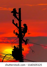 Silhouette Electrical Engineers Working On Electricity Pylon High Tension Power Line Repairs And Maintenance With Blurred Background Beautiful Twilight Sky