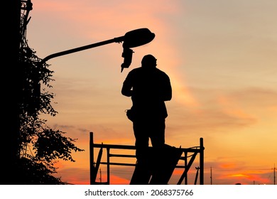 Silhouette Of Electrician Checking Lighting To The LED Street Lamp Post, Technician And Maintenance Service Concepts