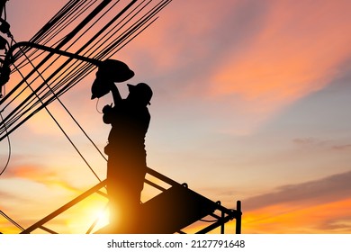 Silhouette of Electrician checking lighting to the LED street lamp post, Technician with clipping path and maintenance service concepts