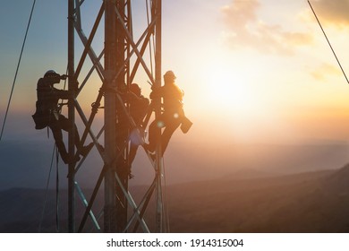 Silhouette electrician work on high ground heavy industry concept. Construction of the extension of high voltage in high voltage stations safely and systematically over blurred natural background.