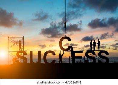 Silhouette employees work as a team to work out successfully over blurred sky at sunset - Shutterstock ID 475616941