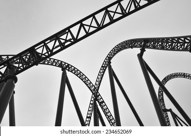 Silhouette of empty roller coaster track a type of amusement ride that employs a form of elevated railroad track designed with tight turns, steep slopes and sometimes inversions.No people.Copy space   - Powered by Shutterstock