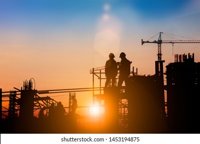 Silhouette of engineer and construction team working at site over blurred background for industry background with Light fair.