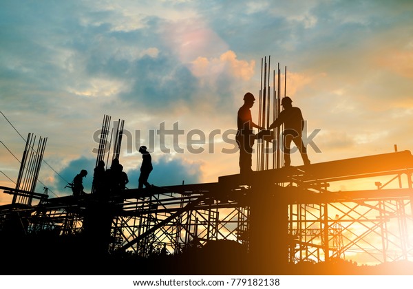 Silhouette of engineer and construction team\
working at site over blurred background sunset pastel for industry\
background with Light\
fair.