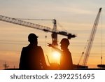 Silhouette of Engineer and foreman worker checking project at building site, construction site blurred sunset in evening time background