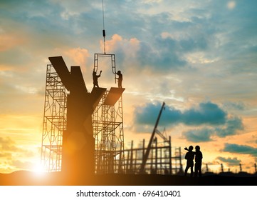Silhouette engineer  look team construction safely to work load scaffolding over blurred background sunset pastel for industry background with Light fair