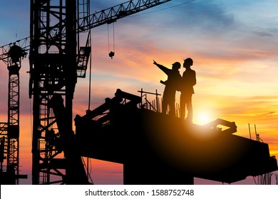 Silhouette Engineer   worker checking project at building site background  construction site at sunset in evening time 