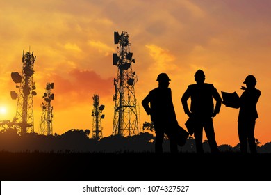 silhouette of the engineers look at the telephone poles planned to be built at sunset time. - Shutterstock ID 1074327527