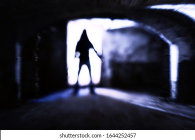 Silhouette Of Evil Theatening Body In Dark Basement - Sinister Figure Standing At Dungeon Door With Dangerous Attitude - Concept Of A Dreadful Encounter With Blurred Subject In Backlight - Image