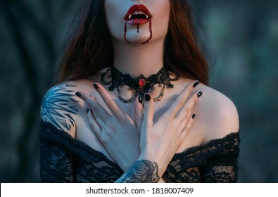 Silhouette of face a attractive sexy vampire woman with sharp teeth fangs, drops of blood flowing on red lips. Close-up portrait of beautiful mouth. Festive art make-up. Gothic lace choker on the neck