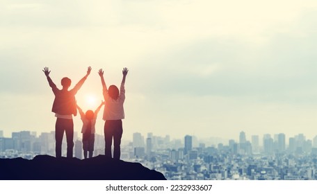 Silhouette of a family looking at the city from the top of a mountain. Family love. Togetherness. - Shutterstock ID 2232933607