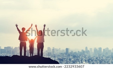 Silhouette of a family looking at the city from the top of a mountain. Family love. Togetherness.