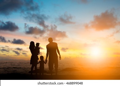 Silhouette family mother, father and young son holding hands, taking a swim in the sea for the first time the children  over blurred beautiful nature.Concept friendly family.flare light.selected focus