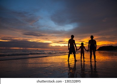 Silhouette Of Family On The Beach At Sunset