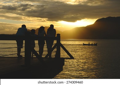 Silhouette Of Family Watching The Sunset