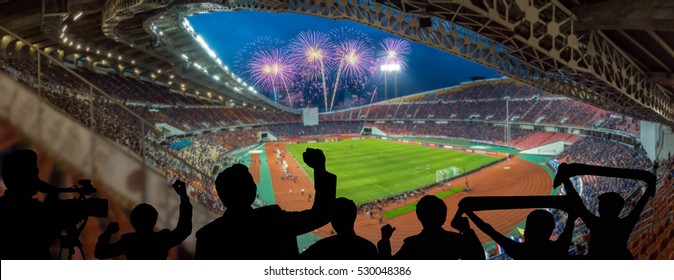 The silhouette of fan club over the panorama of Abstract blurred photo of fan sport at stadium with firework, sport background concept - Shutterstock ID 530048386