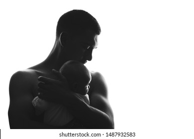 Silhouette Of A Father Man With A Naked Torso With A Newborn Baby In His Arms In An Embrace, Fatherhood, Art Concept