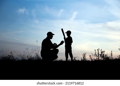 silhouette of father and son playing baseball on nature family sport concept