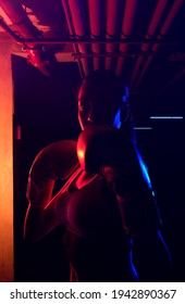 
Silhouette Female Boxer Training, Red Boxing Gloves, Ring With Red And Blue Lights, Industrial Gym, Neon Lights. Selective Focus