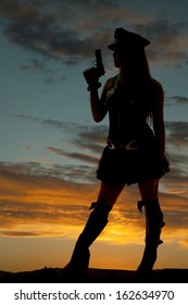 A Silhouette Of A Female Cop Holding Up A Gun.