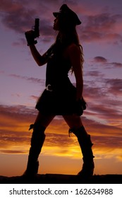 A Silhouette Of A Female Cop Holding Her Gun Up.