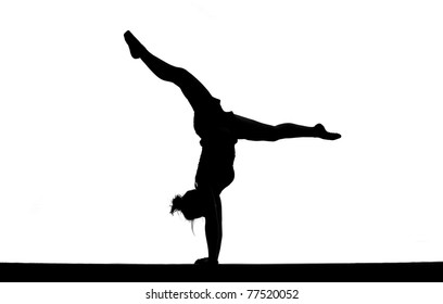 silhouette of female gymnast doing the splits on balance beam