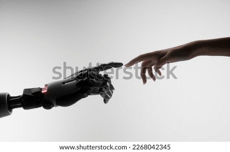 Silhouette of female hand touching the hand of a robot against white background 