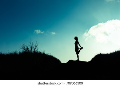 Silhouette of female runner stretching. Healthy active lifestyle. 