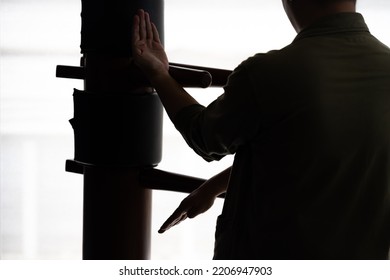 Silhouette of a fighter Wing Chun and wooden dummy on a background. Wing Chun Kung Fu Self defense - Powered by Shutterstock