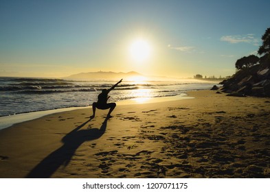 Silhouette Figure In The Sunrise On Beach In Front Of Ocean In Byron Bay, Australia.