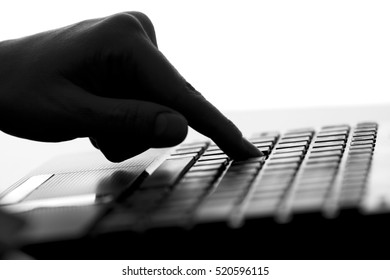 silhouette of the finger of a female hand press a key on the keyboard of the netbook - Powered by Shutterstock