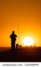 Silhouette Of A Fisherman And Pole On The Beach At Sunset. Jones Beach, Long Island New York