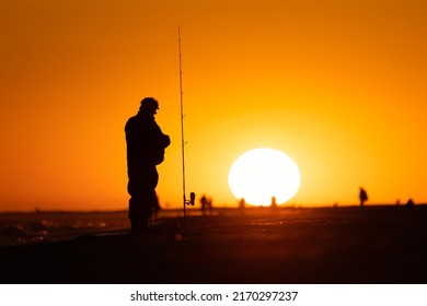 Silhouette Of A Fisherman And Pole On The Beach At Sunset. Jones Beach, Long Island New York