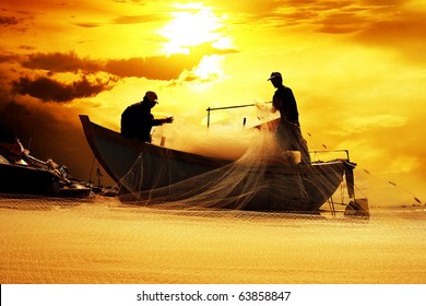 silhouette of fishermen with yellow and orange sun in the background